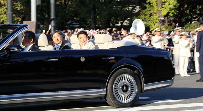 沿道の奉祝者ににこやかな表情で手を振られる両陛下